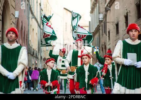 SIENA, ITALIEN - JULI 2013: Mitglieder der edlen Contrada dell'Oca tragen Fahnen mit einer gekrönten Gans auf dem Corteo Storico, einem historischen Kostümparadies Stockfoto