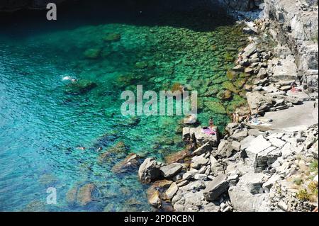 Felsenstrand in Manarola, eines der fünf Jahrhunderte alten Dörfer von Cinque Terre, an der zerklüfteten Nordwestküste der italienischen Riviera, Ligurien, Italien. Stockfoto