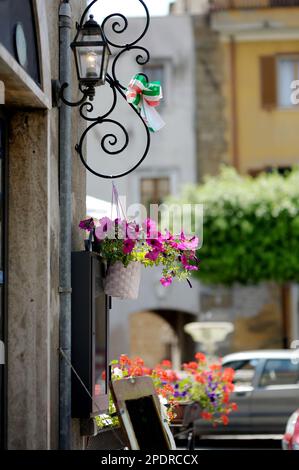 Blumen in den engen alten Straßen der berühmten Stadt Pitigliano, die sich auf einem vulkanischen Tuffsteinkamm befindet. Wunderschöne italienische Städte und Dörfer. Etruskische Herita Stockfoto