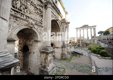 Der Tempel des Saturn und der weiße Marmorbogen des Septimius Severus, der sich auf dem Kapitolshügel befindet. Antike Denkmäler und Ruinen in Roman Fo Stockfoto