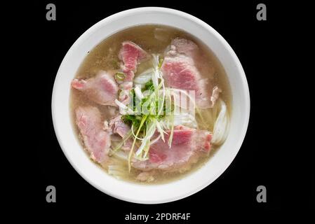 Traditionelle vietnamesische Suppe Pho bo auf schwarzem Hintergrund Stockfoto