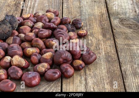 Geröstete süße Kastanien auf einem grauen rustikalen Holztisch. Stockfoto