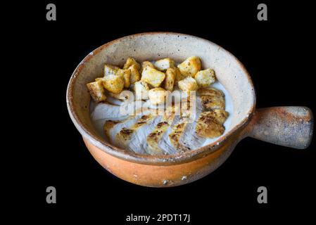 Pilzsuppe mit Huhn und Crackern isoliert auf schwarzem Hintergrund, Seitenansicht Stockfoto