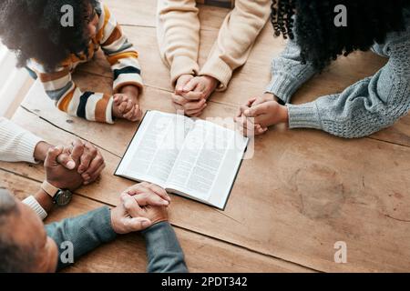 Bibel, Buch lesen oder Hände der Familie im Gebet, Unterstützung oder Hoffnung im Heim des Christentums zur gemeinsamen Verehrung. Mutter, Vater oder Großeltern, die studieren Stockfoto