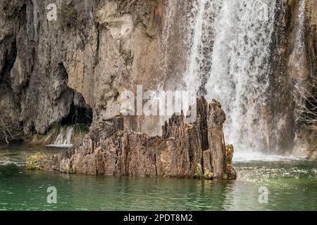 Teilweiser Blick auf den See, Wasserfall mit Wasserfall, der auf scharfe Felsen fällt, Plitvicer Park, Kroatien. Warmer Frühlingstag zum Reisen Stockfoto