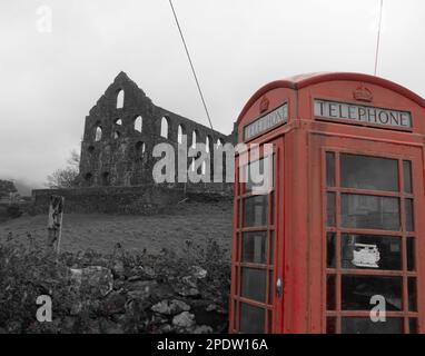 Alte rote Telefonzelle vor einer verfallenen Schiefermühle in Snowdonia Stockfoto