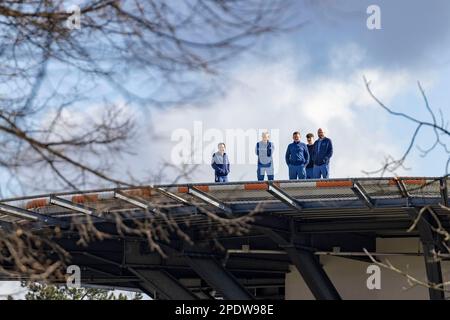 Gelsenkirchen, Deutschland. 15. März 2023. Vom Hubschrauberlandeplatz des Bergmannsheil-Buer-Krankenhauses in Gelsenkirchen sehen einige Krankenhausmitarbeiter die Rallye. Verdi fordert Streiks in vielen nordrhein-westfälischen Städten im Gesundheitswesen. Kredit: Christoph Reichwein/dpa/Alamy Live News Stockfoto