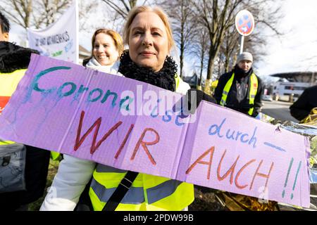 Gelsenkirchen, Deutschland. 15. März 2023. Eine Krankenschwester zeigt ein Schild, auf dem steht, dass Corona vorbei ist - wir auch. Verdi fordert Streiks in vielen nordrhein-westfälischen Städten im Gesundheitswesen. Kredit: Christoph Reichwein/dpa/Alamy Live News Stockfoto