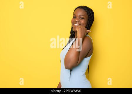 afroamerikanische Frau in legerer Kleidung, die positive Geste mit der Hand bestätigt, lächelnd mit dem Daumen nach oben und glücklich über den Erfolg. Gewinnergeste. Stockfoto