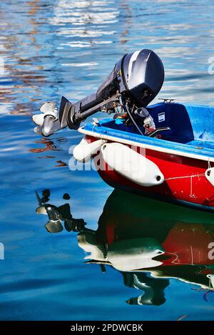 Scilly-Inseln, Vereinigtes Königreich - Details eines Außenbordmotors auf einem kleinen Boot, das im Hafen von Hugh Town im ruhigen Wasser treibt, St. Mary's. Reflexion i Stockfoto