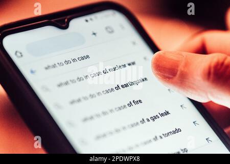 Nahaufnahme der Rückansicht einer Frau, die dystopische Themen sucht, während die Suchmaschine prädiktiven Text erzeugt Stockfoto