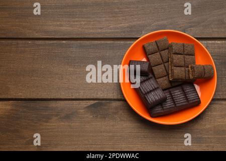 Orangefarbene Platte mit köstlichem und gesundem Hämatogen auf Holztisch, Draufsicht. Platz für Text Stockfoto
