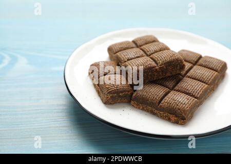 Weiße Platte mit köstlichem und gesundem Hämatogen auf blauem Holztisch, Nahaufnahme Stockfoto
