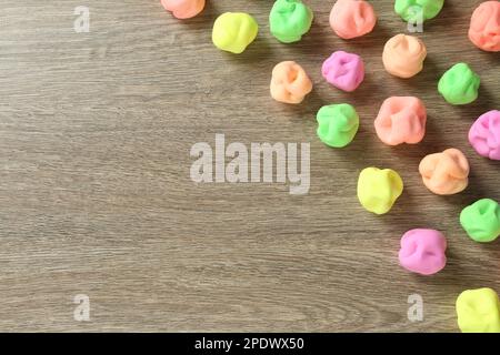 Spielteig in verschiedenen Farben auf Holztisch, flach liegend. Platz für Text Stockfoto