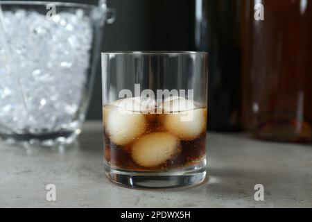 Köstlicher Cocktail mit Eisbällen auf grauem Tisch Stockfoto