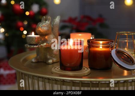 Brennende Kerzen auf dem Tisch im zu Weihnachten dekorierten Zimmer Stockfoto