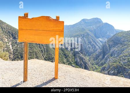 Leerer hölzerner Schild am Aussichtspunkt vor dem Hintergrund des malerischen Bergschluchten. Stockfoto