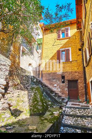 Die schmale Steintreppe führt zum Gipfel des Berges entlang der vintae Wohnhäuser von Albogasio, Valsolda, Italien Stockfoto