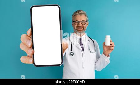 Fröhlicher europäischer Arzt, der Telefon und Medizin zeigt Stockfoto