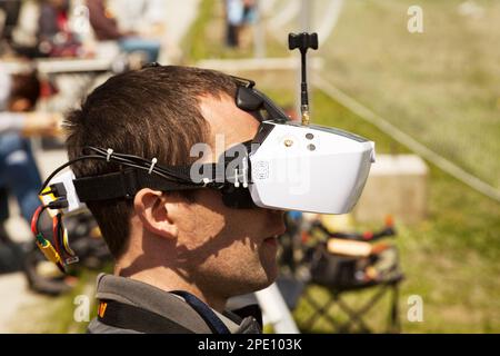 Khabarowsk, Russland - 21. Mai 2017: Drohnenpilot trägt Ego-View-Headset. Junger Mann, der einen Quadcopter mit einer Videobrille fährt Stockfoto