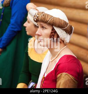 Chabarowsk, Russland - 11. Juni 2017: Mittelalter Kostümen - edle Fräulein tragen rote Kleid, eine Kopfbedeckung und Flechten Frisur. Kaukasische Frau Stockfoto