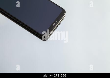 Schwarzes Smartphone Nokia 6,1 Plus auf reflektierender Oberfläche mit Kopierbereich. Modernes Mobiltelefon mit leerem Bildschirm und Firmenlogo Stockfoto