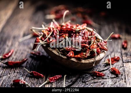 Getrocknete Chili-Paprika in einer Woodem-Schüssel auf einem rustikalen Tisch. Stockfoto