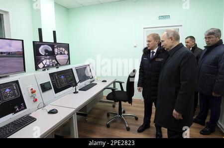 Ulan-Ude, Russland. 14. März 2023. Russischer Präsident Wladimir Putin, Mitte, führt das Ulan-Ude-Flugzeugwerk in Begleitung des Geschäftsführers Alexei Kozlov, Left, und des Leiters der Republik Buryatien Alexei Tsydenov, Right, 14. März 2023 in Ulan-Ude, Buryatien, Russland. Kredit: Mikhail Metzel/Kreml Pool/Alamy Live News Stockfoto