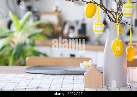 Schlüssel zum Haus eines gemütlichen Hauses mit Osterdekor mit Hase und Eiern auf dem Tisch der Küche. Gebäude, Entwurf, Projekt, Umzug in ein neues Haus, Hypothek, Versicherung Stockfoto