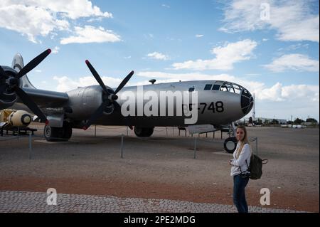 Ein junges Mädchen vor einem alten Kriegsbombenflugzeug Stockfoto