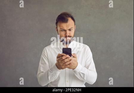 Millennial man ist verärgert über das langsame Internet, hat eine Spam-Nachricht erhalten oder hat ein Telefonproblem. Stockfoto