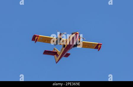 Canadair-Flug, Feuerwehrflugzeug, Scooper-Flug auf blauem Himmel im Hintergrund, unter Sicht. Gelbrote Farbe Wasserflugzeug für Rettung und Transport. Stockfoto