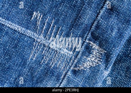 Details der blauen Jeans mit dekorativen Nähten im Hintergrund Stockfoto