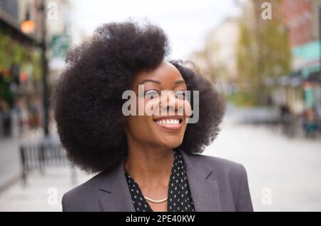 Eine junge afroamerikanische Geschäftsfrau in einem grauen Anzug Stockfoto