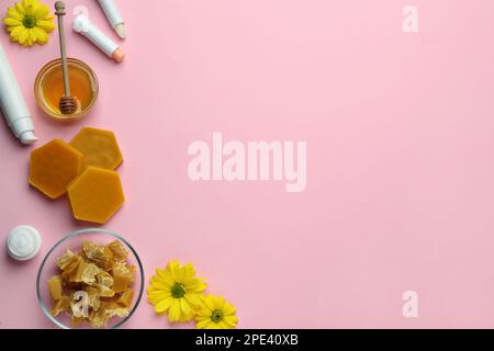 Flache Laienzusammensetzung mit Bienenwachs und kosmetischen Mitteln auf pinkfarbenem Hintergrund. Platz für Text Stockfoto