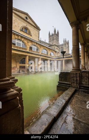 Schnee fällt auf das große Bad in den römischen Bädern in Bath, Somerset Stockfoto