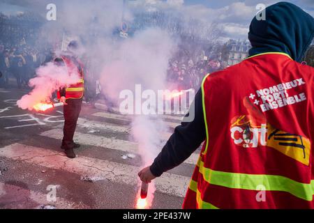 Paris, FRANKREICH. 15. März 2023. Die Mitglieder der kommunistischen Gewerkschaft CGT benutzen Fackeln, wenn zehntausende Menschen im Zentrum von Paris gegen Rentenreformpläne marschieren. Die Pläne der Regierung Emmanuel Macron, das Rentenalter von 62 auf 64 Jahre anzuheben, stießen auf Zorn und Proteste. Kredit: ZUMA Press, Inc./Alamy Live News Stockfoto