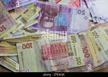 Papiergeld verschiedene Stückelungen, ukrainische Hrywna in Stückelungen 50.100, 200 Hrywna, neues Geld, Hintergrund mit verstreuten Banknoten. Stockfoto