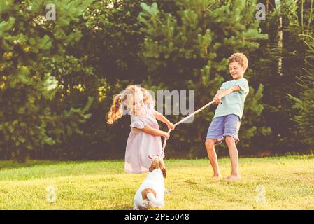 Kinder, die mit ihrem Haustier spielen, ziehen Kriegsspiel Stockfoto