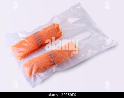 Lachsscheiben in vakuumverpackter Verpackung, versiegelt für Sous-Vide-Kochen auf weißem Hintergrund Stockfoto