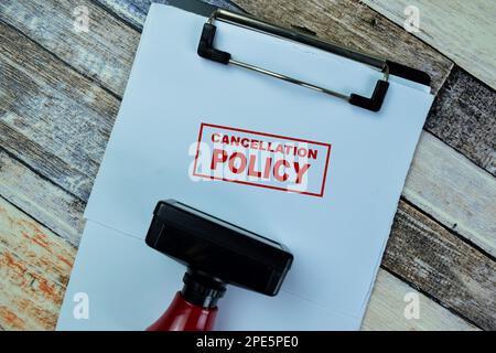 Konzept des roten Griffs Gummistempel und Stornierungsbedingungen Text isoliert auf Holztisch. Stockfoto