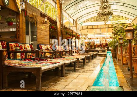 Kashan, Iran - 27. Mai 2022: Traditionelle gemütliche Cafés, Restaurants mit dekoriertem Interieur, gemütlichen Sitzen und Springbrunnen Stockfoto