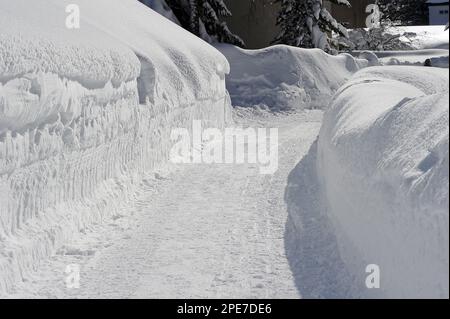 Freigelegte Straße durch Schneewehre, Davos, Graubunden, Schweizer Alpen, Schweiz Stockfoto