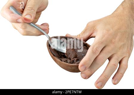 Die Hand eines Mannes, der die ostereifüllung mit einem Löffel aufnimmt. Stockfoto