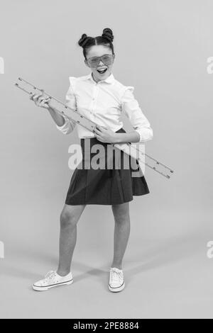 Lächelndes Teenager-Mädchen halten Lineal. Zurück in die Schule. Algebra und Geometrie. Kind studieren Mathematik. Stockfoto