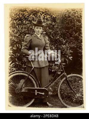 Original viktorianisches Foto einer jungen viktorianischen Radfahrerin mit ihrem Fahrrad in einem Garten, um 1898, Worcester Area, Großbritannien Stockfoto