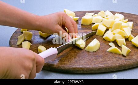 Schneiden Sie die Kartoffeln in Stücke Stockfoto