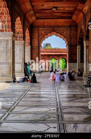 Indische muslimische Gläubige sitzen auf dem Boden der Jama Masjid Moschee in Delhi Stockfoto