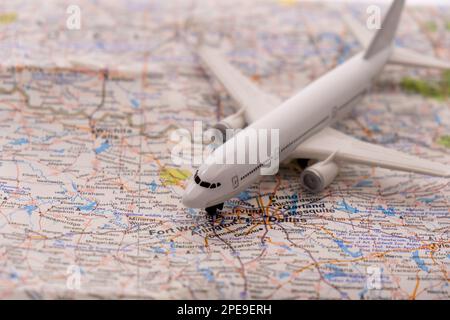 Nahaufnahme eines Miniatur-Passagierflugzeugs auf einer farbenfrohen Karte mit Fokus auf Dallas Fort Worth Texas durch selektive Fokussierung, Hintergrundunschärfe Stockfoto