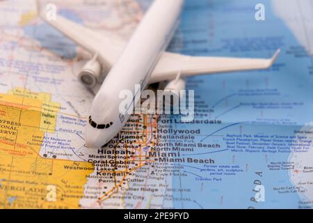 Passagierflugzeug auf einer Karte, das Miami, Florida durch selektive Fokussierung hervorhebt Stockfoto